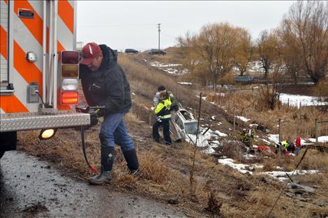Emergency workers carry a child to safety and strap Stacie Rongwycsik-Lester onto a back board from a March 10 wreck where a car flipped over a railing and into the ravine of an animal crossing. 