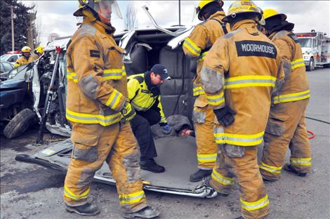 Ronan volunteer firefighters attempt to rescue Ronan High School Principal Kevin Kenelty during a mock fatal drunken driving wreck staged at Ronan High School.