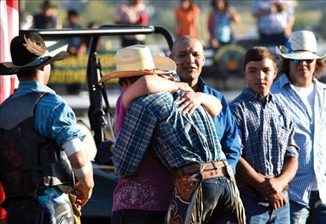 Payton Fitzpatrick receives a big hug from Terri Cleveland as the benefit bull-a-rama gets underway at the Polson Fairgrounds.