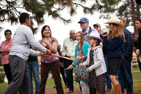  Paul Phillips demonstrates a Native stickball game with Annabelle Gunderson and Ellie Dupuis during Sunday’s Feather the Nest fundraiser. 