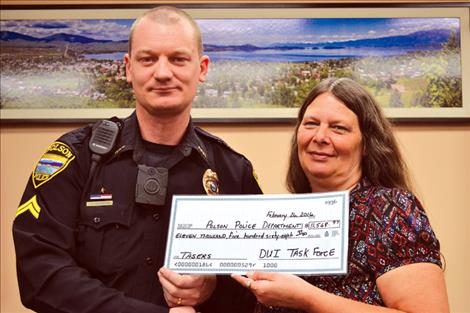Polson Police Corporal George Simpson said he appreciates the Lake County DUI Task Force’s $11,568.67 donation that was used to purchase new tasers. Presenting the check is Jill Campbell, Lake County DUI Task Force coordinator.