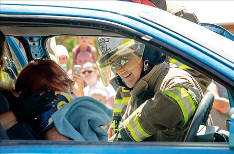 During a mock rescue, a Polson firefighter checks to see if Jennaveve Umphrey is doing well while the car is cut open with the Jaws-of-Life. 