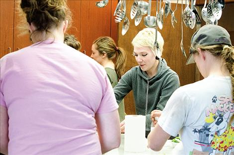 Addie McMurry, works with a group of participants to make a quick healthy meal during a workshop.  