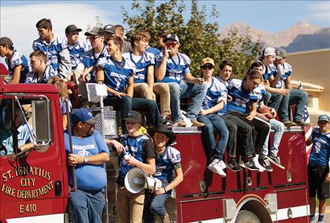 The Bulldog football team rides on the St. Ignatius City Fire  Department truck  during the parade. 