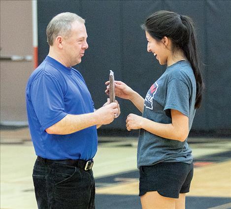 Mission’s Karolyna Buck accepts an award from Steve Woll for winning the girls' three-point competition. 