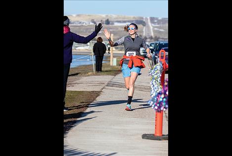 Bea Frissell receives a first place high five as she crosses the finish line.