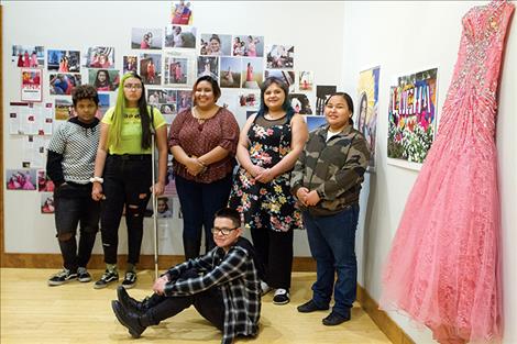 A group of Two Eagle River School student photographers stand for a picture next to their photography exhibit in the Zootown Arts Community Center Gallery in Missoula.