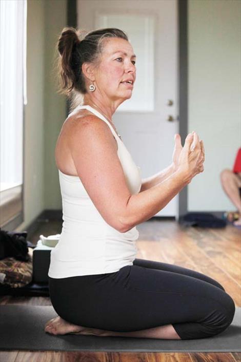 Bonnie Kiser explains a yoga pose.