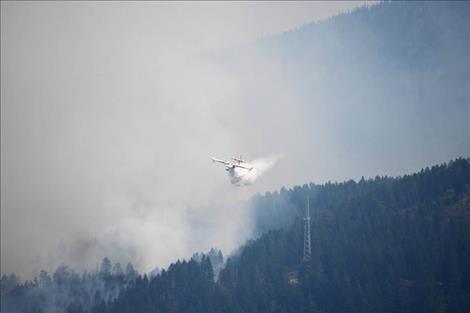 A scooper plane gets water from Flathead Lake and dumps it on the Boulder 2700 fire.