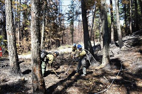 Fire crews douse hot spots  at the Boulder 2700 fire on  Wednesday.