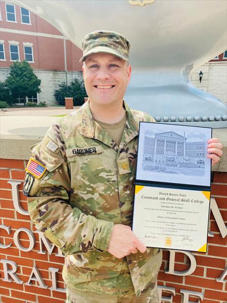 Major Jonathan Gardner displays his master’s degree in front of the United States Army Command and General Staff College at Fort Leavenworth.
