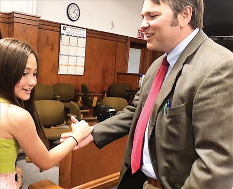 Cora Lapotka gives her dad, Lake County Attorney James Lapotka, a high-five during last Thursday’s swearing-in at the county courthouse in Polson.