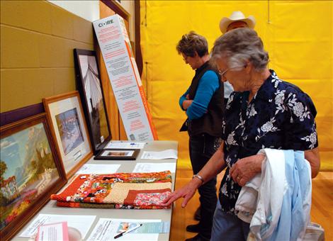 Phyllis Dresen examines a baby quilt at the silent auction at the Bella and Bridger fundraiser spaghetti feed. More than 180 items were donated for the silent auction.
