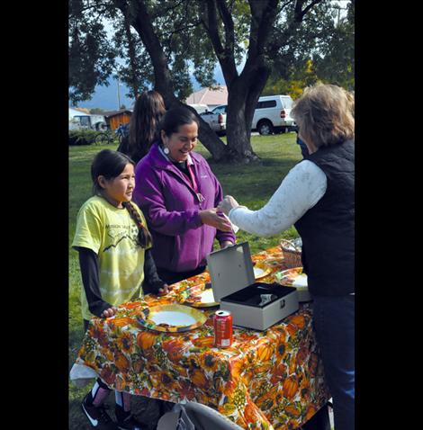 Ronna Walchuk takes donations and hands out plates at the pig in the park event.