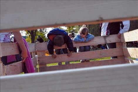 Xavier St. Clair and Milee Cordier watch a pig. 