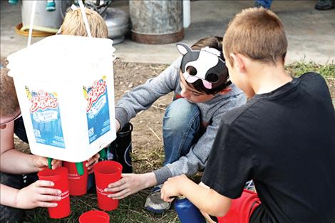 Kids learn how to milk cows with simulated udders. 