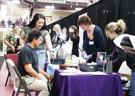 Jessica Schallock with Fellowship Fitness talks to a health fair attendee about free fitness classes offered to the community.