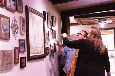 Behavior Service Director Jessica Barnette and Lisa Jones-Park from Missoula look at a wall filled with client photos.