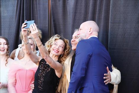 Kate Orsini, Andrew Roa, and Graham McTavish snap a selfie on the red carpet.