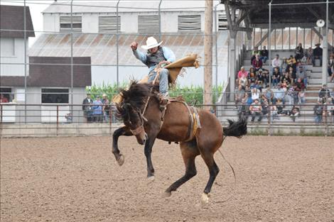 A cowboy competes in the bronc riding competiton.