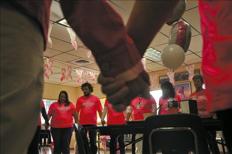 People hold hands and share stories of those affected by cancer at an event hosted by the Salish Kootenai College Center for Prevention and Wellness. 