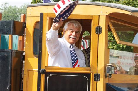 Dressed in patriotic attire for the occasion, Lake County Commissioner Bill Barron waves during the centennial parade.