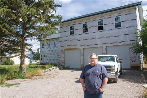 Zach Miller stands in front of the “dream home” he started building prior to his employment termination and the post-pandemic increase in building material costs. 