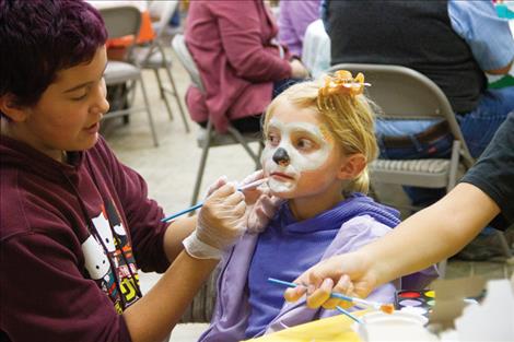 Kiara Brooksallen paints a koala face on Freja Nelson.