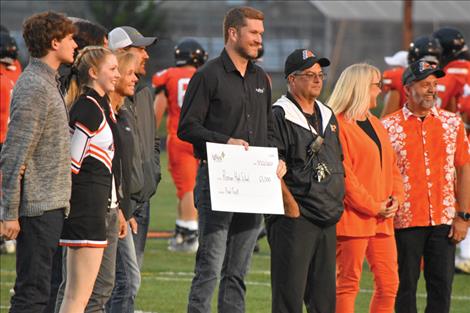 AgWest Vice President Scott Kesler, center,  presents RHS students with a $65,000 check during a break at the Sept. 22 homecoming football game.