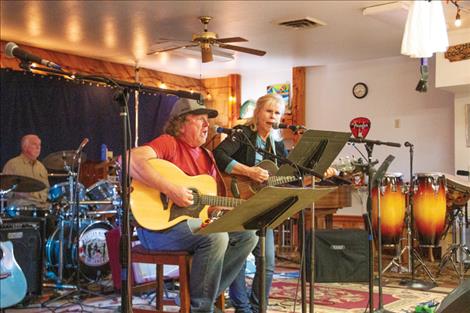Sid Seay and Keryl Lozar play guitar and sing on stage during a Saturday Open Jam night at the Western Montana Musicians Co-op in Ronan.