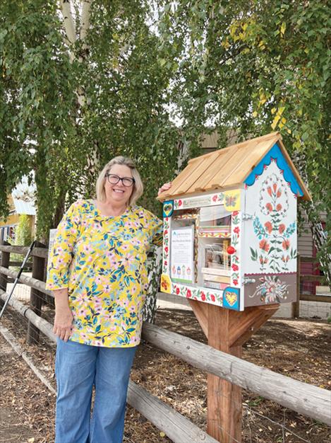 Mimi Hildebrandt stands next to the Little Free Library Mission Valley, located in front of Mission Valley Properties in St Ignatius.