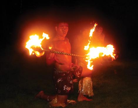 A Tribal Waves member twirls a stick burning at both ends to entertain guests at the GPCF  annual fundraiser. Tribal Waves is a local fire dancing troupe.