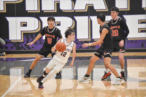   Polson Pirate basketball player Jesse Vail looks for an open channel during last Saturday’s game against Ronan. The evening was also Polson senior night.    