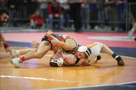 Ronan Maiden wrestler River Cote works to pin her opponent beneath her. Cote is the girls state champion at 100 pounds.