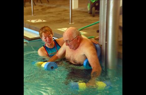  Chuck works with foam dumbbells, pushing them underneath the water. He's gone up two weights since he began. 