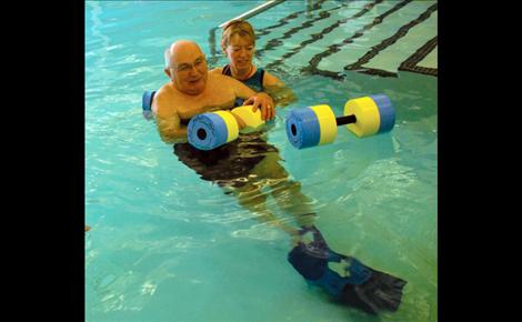  Chuck works with foam dumbbells, pushing them underneath the water. He's gone up two weights since he began. 