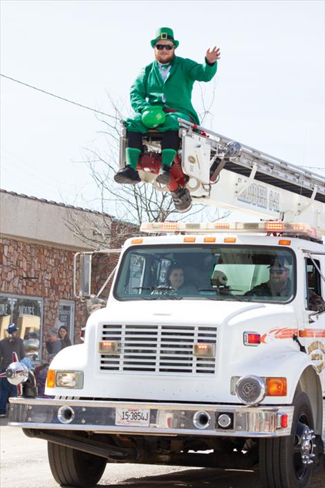  A friendly leprechaun waves from atop a Ronan fire truck. 