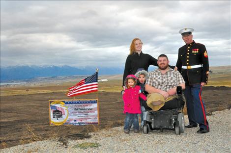 Tomy Parker and Amanda Hout pose with daughters Eva and Olivia and Marine Veteran Sgt. Chuck Lewis in front of the piece of land where their future home will be built. 