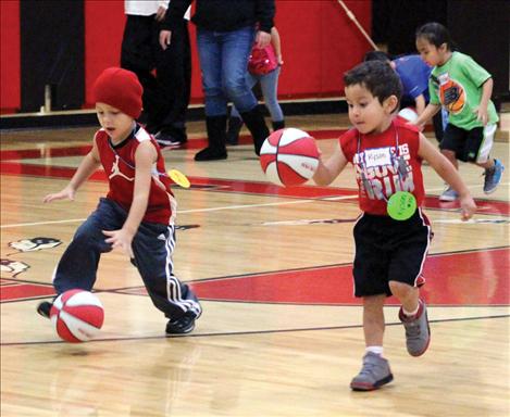 Young players practice their skills by dribbling itty bitty basketballs.