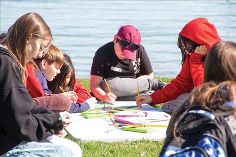 Polson seventh grader Griffey Wishman, center, and his classmates draw their own invasive “aquamon” creatures.