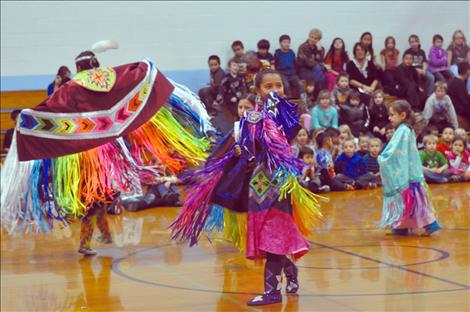 Students at K. William Harvey Elementary School in Ronan watch native dancers in a round dance.