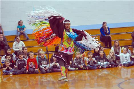 Students at K. William Harvey Elementary School in Ronan watch native dancers in a round dance.