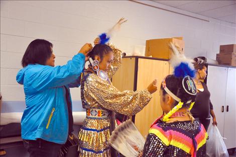 Cher Perdash arranges the eagle feathers of her daugher Stormie Perdash.