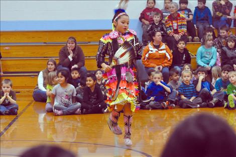 Students at K. William Harvey Elementary School in Ronan watch native dancers in a round dance.