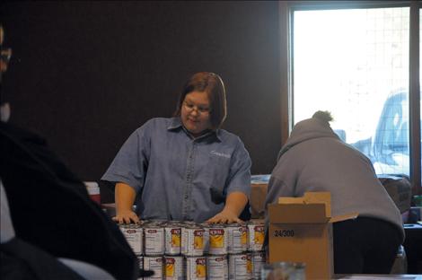 Crystal Horsely helps unstack canned goods.