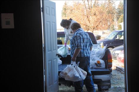 Joanne Shaw works with Kicking Horse Job Corps students to load bags of groceries that will be given to the elderly and small children.  