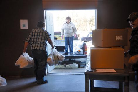 Joanne Shaw works with Kicking Horse Job Corps students to load bags of groceries that will be given to the elderly and small children.  