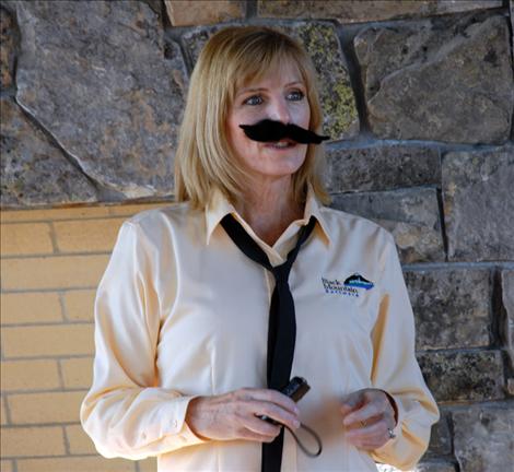 Darlis Smith sports a mustache as she emcees the Movember event at Black Mountain Software.