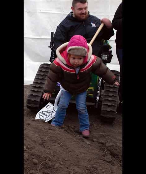 Using a “shovel” more her size and a cup, Olivia has her own groundbreaking.