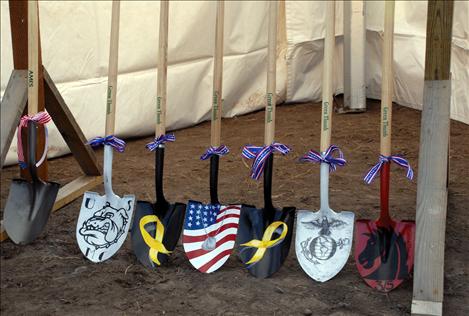 Johnie Parker, Tomy’s sister, paints shovels for the official groundbreaking of Tomy’s new house. She took up painting after Tomy was wounded to keep herself busy.